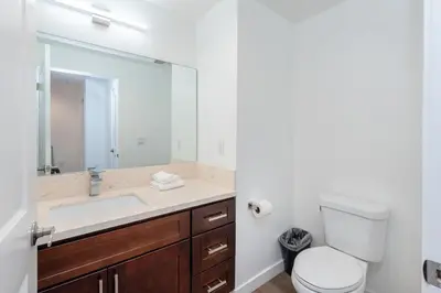 a bathroom with a sink and a toilet and a mirror at Luxury 2BR Stay Balcony Views and Free Parking in Los Angeles
