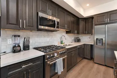 a kitchen with wooden cabinets and a stainless steel refrigerator at Modern and Chic 2BR Gem with Luxe Finishes, Parking in Los Angeles