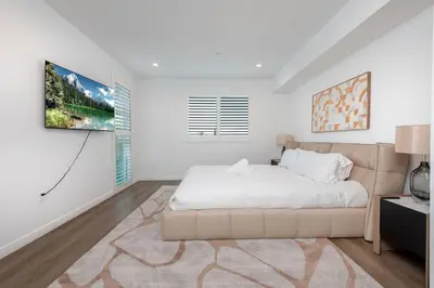 a white bedroom with a large bed and a window at Modern and Chic 2BR Gem with Luxe Finishes, Parking in Los Angeles