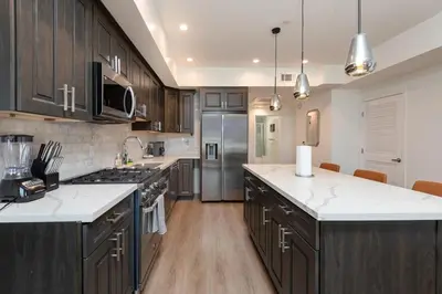 a large kitchen with wooden cabinets and white counter tops at Modern and Chic 2BR Gem with Luxe Finishes, Parking in Los Angeles