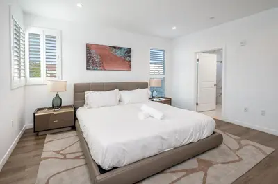 a white bedroom with a large bed with white sheets at Experience Lavish LA Living Sleek 2BR with Parking in Los Angeles