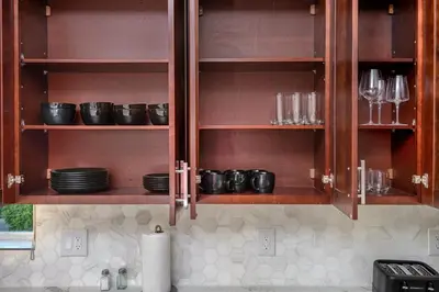 a kitchen with wooden cabinets with plates and glasses at Ultimate Luxurious Penthouse with Private Balcony in Los Angeles