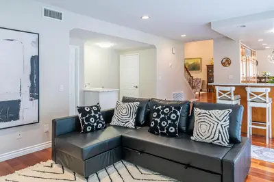 a living room with a black couch with pillows at Luxurious Villa in Diamond Bar- Private Cul-de-Sac in Diamond Bar