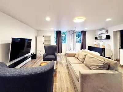 a living room with a couch and a flat screen tv at Cozy LA Studio Steps from SoFi and LAX - SH3 - LAD in Los Angeles