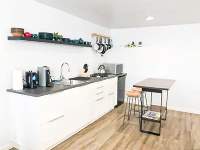 a white kitchen with a sink and a counter at Cozy LA Studio Steps from SoFi and LAX - SH3 - LAD in Los Angeles