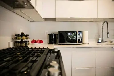 a kitchen with a stove and a microwave at Bright 2-BR Home Near LAX with Shared Yard - SH2-LAD in Los Angeles