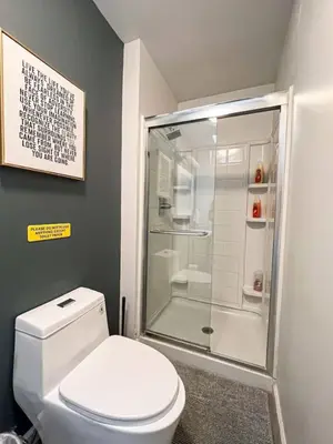 a bathroom with a toilet and a glass shower at Bright 2-BR Home Near LAX with Shared Yard - SH2-LAD in Los Angeles