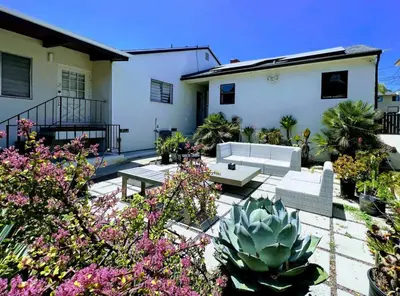 a patio with couches and plants in front of a house at Bright 2-BR Home Near LAX with Shared Yard - SH2-LAD in Los Angeles