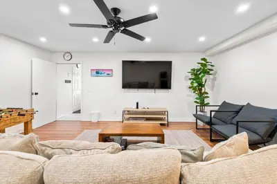 a living room with a couch and a ceiling fan at Game Room & In-Unit Laundry - 15 Min to Disney! in Artesia