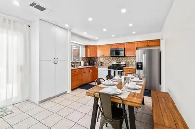 a kitchen with a wooden table and a dining room at Game Room & In-Unit Laundry - 15 Min to Disney! in Artesia