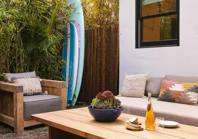 a table with a bowl of fruit on a patio with a surfboard at Channel Islands Beach Retreat in Oxnard