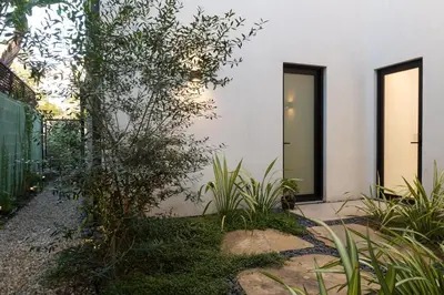 a white house with plants in front of it at Luxury suite with private entrance in Los Angeles