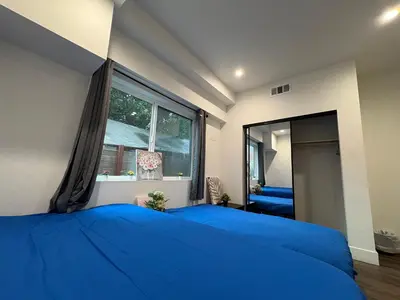 a bedroom with a blue bed and a large window at Blue Stay Walk to BMO Stadium and USC in Los Angeles