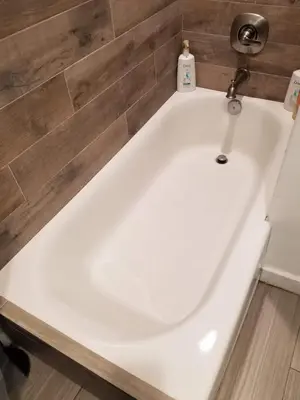 a white bath tub in a bathroom with a tile wall at 3 bedroom with Hot Tub and Video game console 10 minutes from Rodeo Drive Beverly Hills in Los Angeles