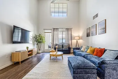 a living room with a blue couch and a tv at Modern Townhouse with 4 Bedrooms Near LAX in Los Angeles