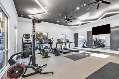 a gym with several tread machines and a flat screen tv at Modern Townhouse with 4 Bedrooms Near LAX in Los Angeles