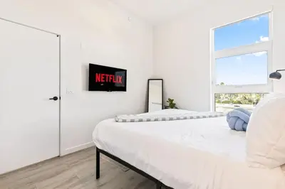 a white bedroom with two beds and a window at Modern Living, Stunning city views, 1Mile to Dodger Stadium in Los Angeles