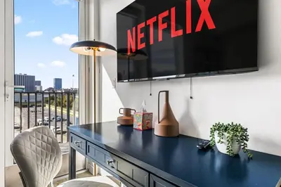 a blue desk with a television on a wall at The Sky loft Suite, DTLA Sunset Views in Los Angeles