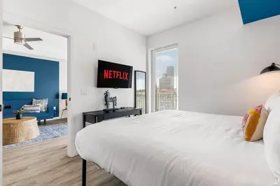a white bedroom with a large bed and a window at The Sky loft Suite, DTLA Sunset Views in Los Angeles