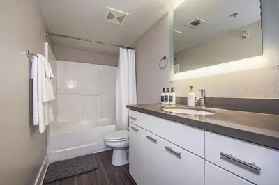 a bathroom with a sink and a toilet and a mirror at Sunny 2BDR in SM Pool & Gym - 5 min to the beach! in Los Angeles