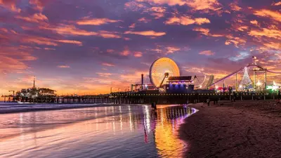 a pier with a ferris wheel on the beach at sunset at Sunny 2BDR in SM Pool & Gym - 5 min to the beach! in Los Angeles