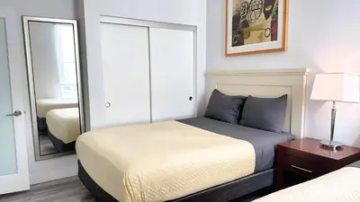 a bedroom with a bed and a mirror at Melrose Luxe Retreat near The Grove in Los Angeles