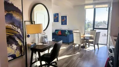 a living room with a table and a mirror at Melrose Luxe Retreat near The Grove in Los Angeles