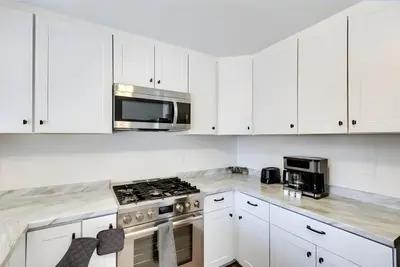 a kitchen with white cabinets and a stove top oven at Modern 4-BR near China Lake in Ridgecrest