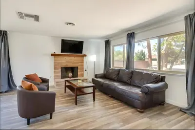 a living room with a leather couch and a fireplace at Modern 4-BR near China Lake in Ridgecrest