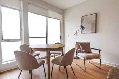 a table and chairs in a room with windows at 2BR Condo in Santa Monica - Walking Distance to Beach, Dining, Shopping & Promenade in Los Angeles