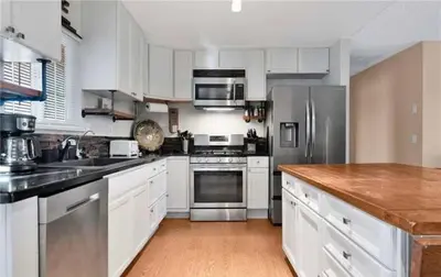 a kitchen with white cabinets and stainless steel appliances at Western style pool home, 4 bedroom and large yard in Apple Valley