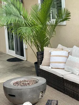 a fire pit in a patio with a couch and a palm tree at The 3BR-2BA Extended Stay Oasis in Anaheim in Anaheim