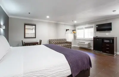 a bedroom with a large bed and a television at Elev8 Hotel Los Angeles, LAX in Inglewood
