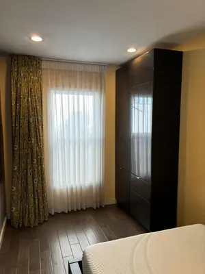 a bedroom with a bed and a dresser and a window at west hollywood condo in Los Angeles