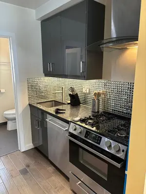 a kitchen with black cabinets and a stove top oven at west hollywood condo in Los Angeles