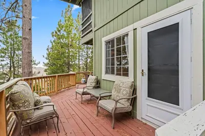 a green house with chairs and a porch at Casa de Yukon & Black stone Grill, 3 Level Home in Lake Arrowhead