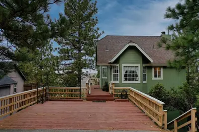 a green house with a wooden ramp leading up to it at Casa de Yukon & Black stone Grill, 3 Level Home in Lake Arrowhead