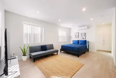 a bedroom with a blue bed and a couch at Prestige Studio Haven at Burbank in Burbank