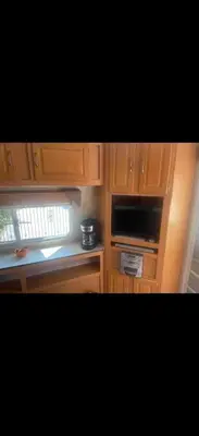 a kitchen with wooden cabinets and a stove top oven at Cozy private couples camper in San Gabriel CA in San Gabriel