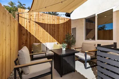 a patio with a table and chairs and a fence at The Oaks, Stylish Luxury Stay, Fire Pit & Patio in Thousand Oaks
