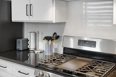 a kitchen with a stove top oven and white cabinets at Cozy 3BR in San Gabriel in San Gabriel