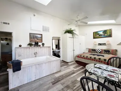 a bathroom with a tub and a bed in a room at Pine Knot Guest Ranch in Big Bear Lake