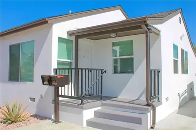a white house with a porch and stairs at Single family house in Long Beach