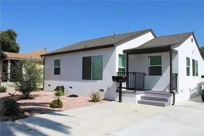 a white house with a porch and a driveway at Single family house in Long Beach