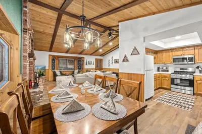 a kitchen and dining room with a dining table and a kitchen and a living room at Nest and Needles in Big Bear Lake