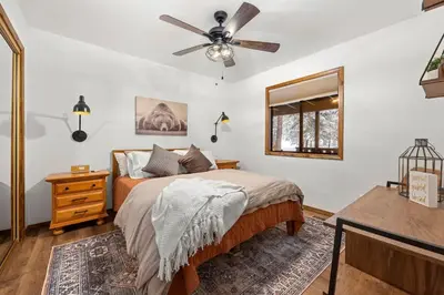a bedroom with a bed and a ceiling fan at Nest and Needles in Big Bear Lake