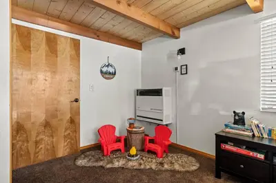 a living room with two red chairs and a table at Wild Heart Cabin in Big Bear Lake