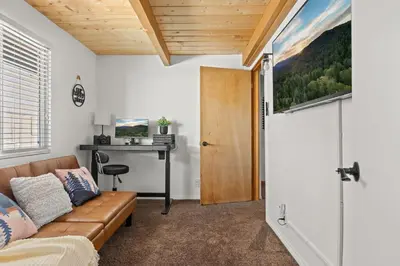 a living room with a couch and a desk at Wild Heart Cabin in Big Bear Lake