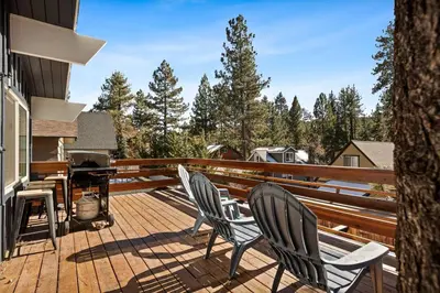 two chairs sitting on a deck with a grill at Wild Heart Cabin in Big Bear Lake