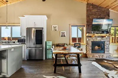 a kitchen with a table and a fireplace at High Altitude Retreat in Big Bear Lake